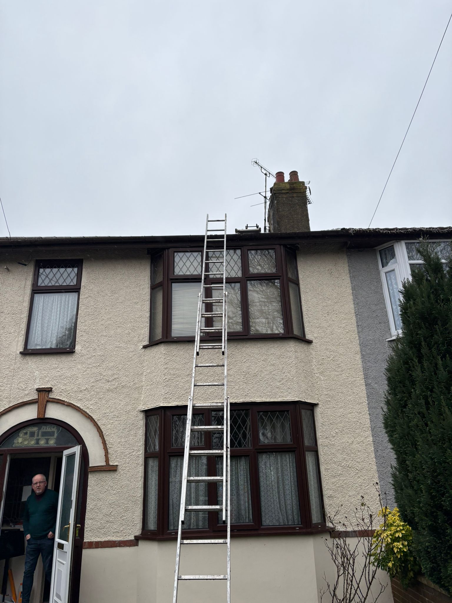 Semi-detached house with ladder to roof and chimney